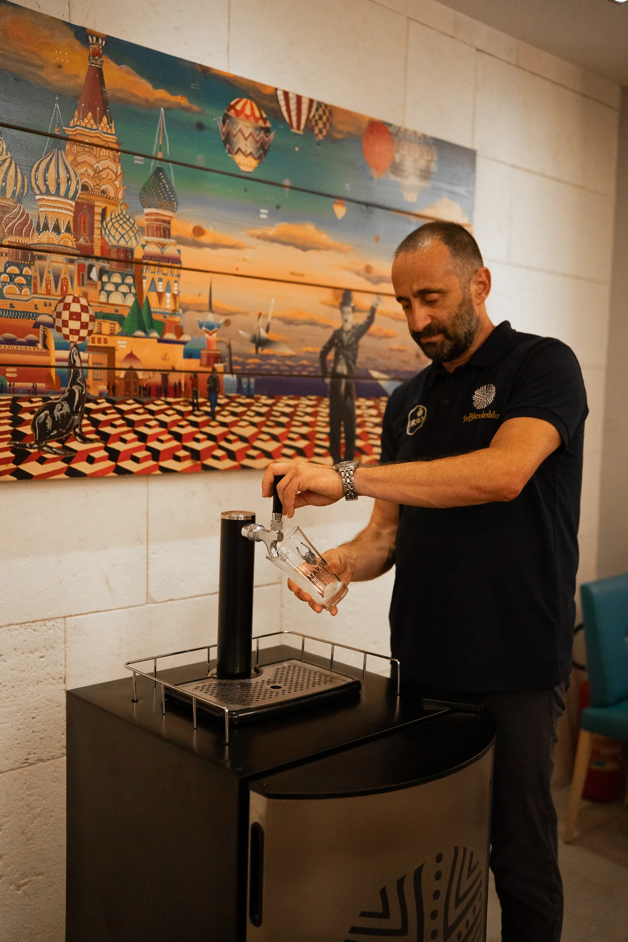 Un uomo riempie un bicchiere dalla colonna della birra.