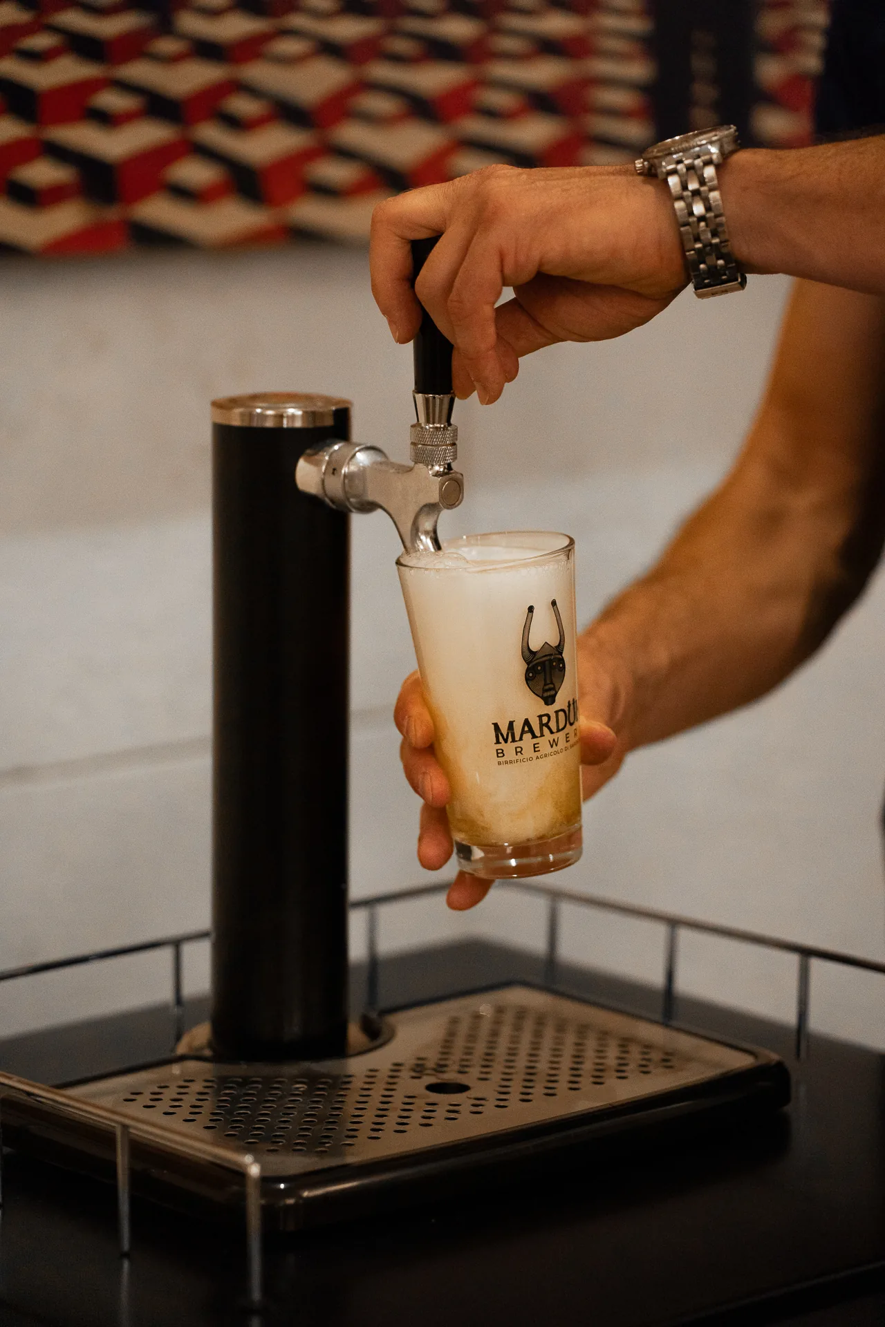 Primo piano di mani che spillano una birra.