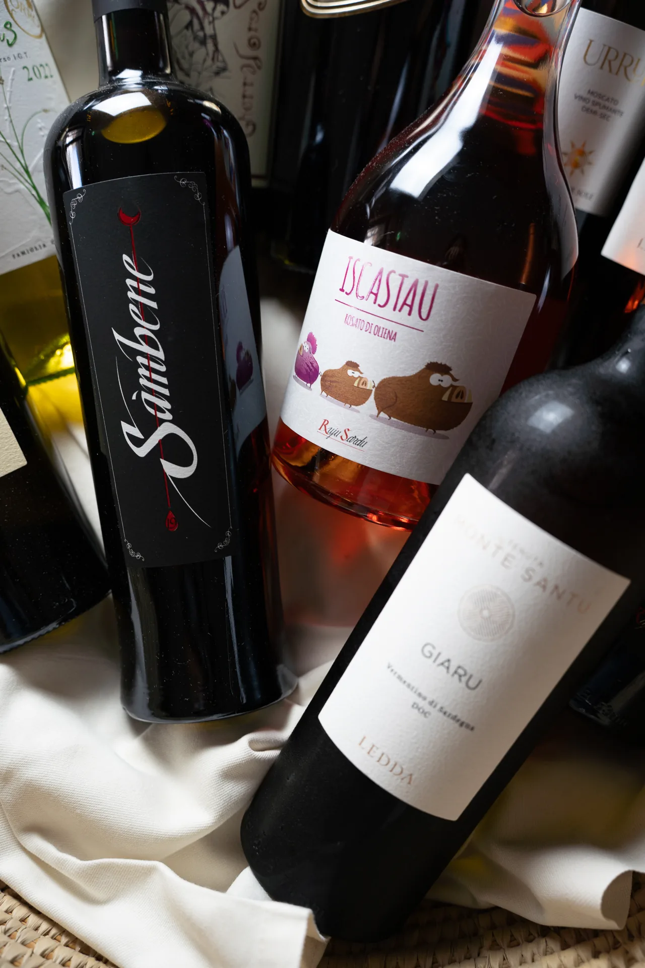 Primo piano di bottiglie di vino con etichette visibili.